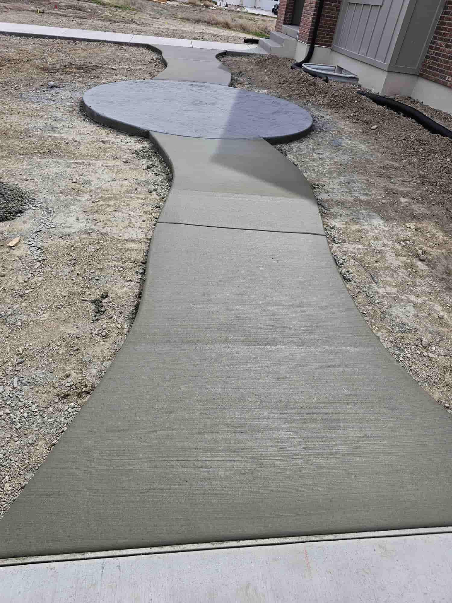Finished broom-textured walkway curving away from a house